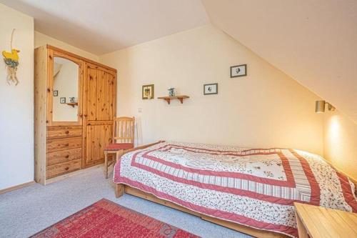 a bedroom with a bed and a wooden cabinet at Fewo-Inselblick in Nordstrand