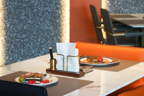 two plates of food sitting on a table at Arthur Hotel Liwan COCO Park Dongsha Metro Guangzhou-24H Coffee & Low Tea & Free Shuttle Bus For Canton Fair By Paco in Guangzhou