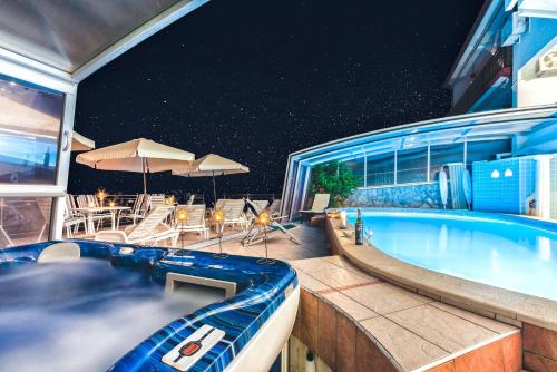 a swimming pool on top of a house at night at Villa Roses Apartments & Wellness in Ičići