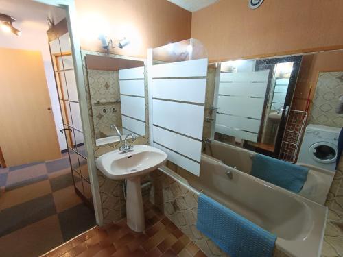 une salle de bain avec un lavabo, un miroir et une baignoire dans l'établissement Appartement face aux pistes - Animaux acceptés - FR-1-445-222, à Montgenèvre