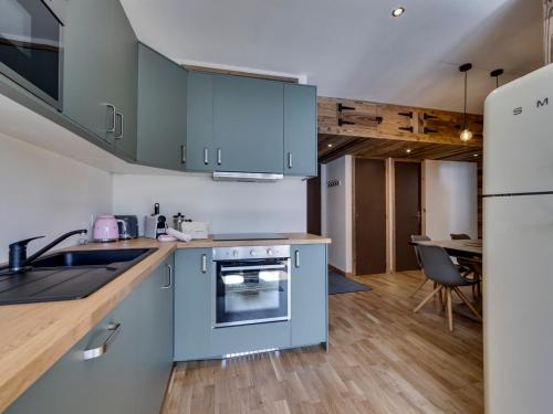une cuisine avec des armoires bleues et une salle à manger dans l'établissement Appartement Tignes 7 pers, 3 ch, proche pistes - FR-1-641-118, à Tignes