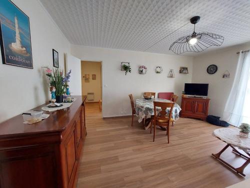 un salon avec une table et une salle à manger dans l'établissement Spacieux 2 pièces avec balcon et parking proche gare, Royan - FR-1-550-93, à Royan