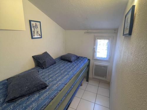 une petite chambre avec un lit et une fenêtre dans l'établissement Pavillon 2 Pièces avec Terrasse, Piscine et Parking à 600m de la Plage - FR-1-701-92, à Vendres