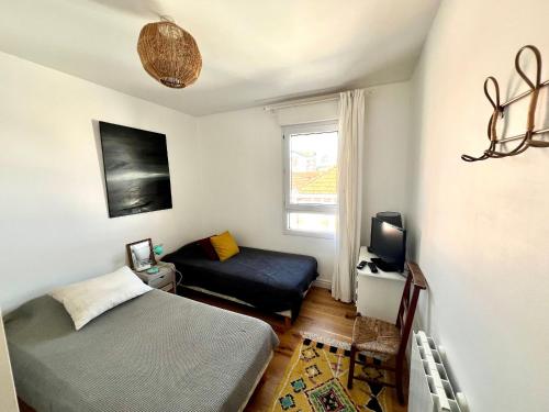 une petite chambre avec deux lits et une fenêtre dans l'établissement Arcachon Centre Ville - T2 Confortable Proche Plage - FR-1-319-611, à Arcachon