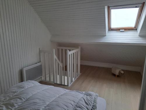Cette chambre mansardée comprend un lit et une fenêtre. dans l'établissement Appartement Rénové 4 Pers. Vue Mer à Fort-Mahon avec Parking - FR-1-482-157, à Fort-Mahon-Plage