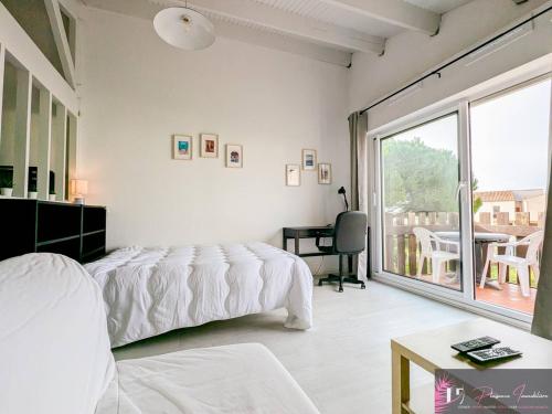 une chambre avec un lit, un bureau et une fenêtre dans l'établissement Studio confortable à La Rochelle avec balcon - FR-1-825-68, à La Rochelle