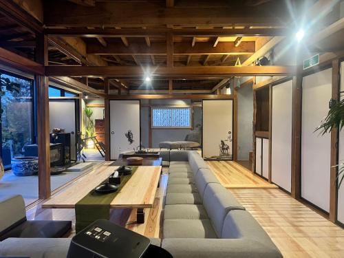a living room with a couch and a table at 薪ストーブの古民家一軒宿アゼミチタベネル in Shimo-ayashi