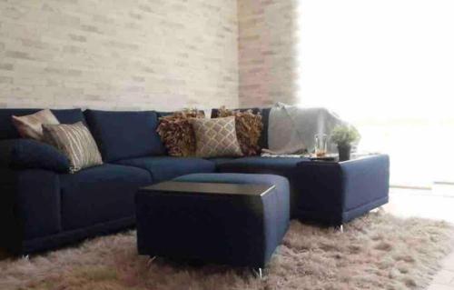 a living room with a blue couch and a table at Departamento terraza hulu in Guanajuato
