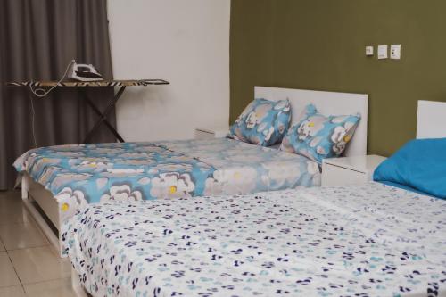 a bedroom with two beds with blue comforter at Chic appartement à la Riviera Palmeraie in Abidjan