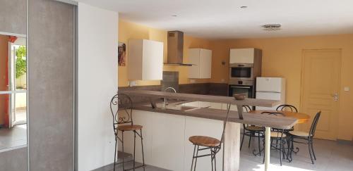 - une cuisine avec un comptoir et des tabourets dans l'établissement Maison entière garage à 5 minute à pied des grands buffets et centre ville, à Narbonne