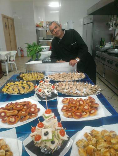 a man standing in front of a table of food at Salisù Country House in Mignano Monte Lungo