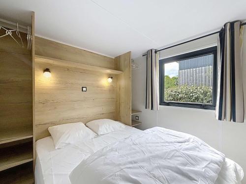 une chambre avec un lit blanc et une fenêtre dans l'établissement Séjour en Tiny House à Jullouville, piscine et parking inclus - FR-1-361A-95, à Jullouville
