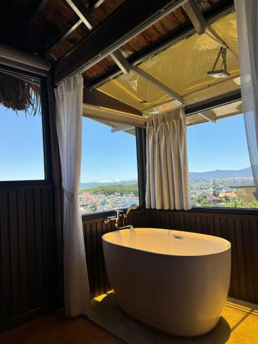 a large bath tub in a room with a large window at Ami Hotel Da Lat in Da Lat