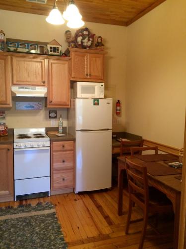 a kitchen with a white refrigerator and a table at Calhoun House Inn & Suites in Bryson City