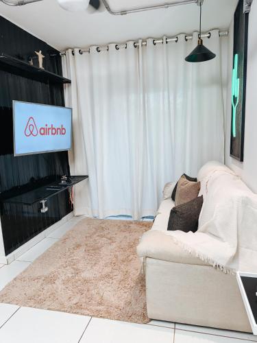 a living room with a couch and a tv at APTO 5 MINUTOS LAGOA MAIOR in Três Lagoas