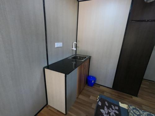 a small room with a sink and a mirror at Hallimane Homestay in Udupi