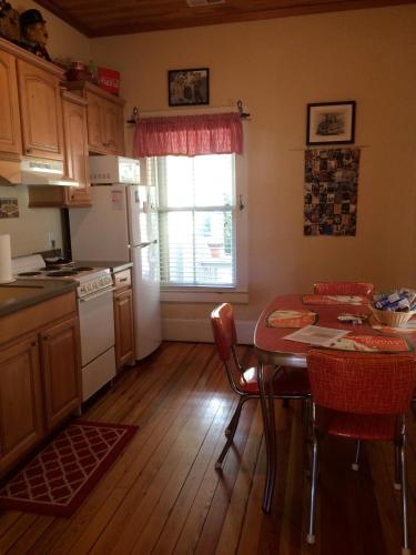 a kitchen with a table with chairs and a refrigerator at Calhoun House Inn & Suites in Bryson City
