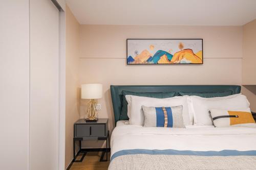 a bedroom with a bed with a green headboard at Zun Xiang Executive Apartment - Shenzhen Futian Exhibition Center in Shenzhen