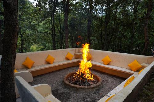 a fire pit with pillows on it in a park at Two Luxury Tents in Majkhali - Buransh & Deodar in Chaubattia