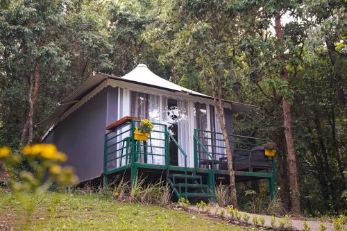 a small purple and green house in the woods at Two Luxury Tents in Majkhali - Buransh & Deodar in Chaubattia