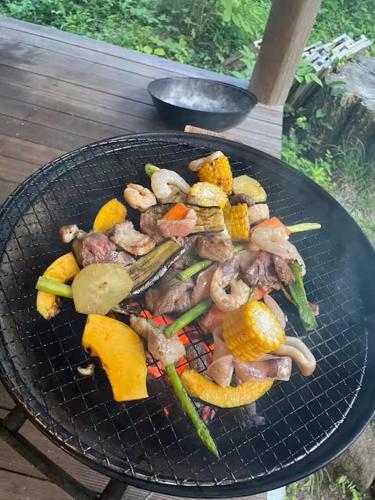 a grill with meat and vegetables on it at Kartoffel in Kita-karuizawa