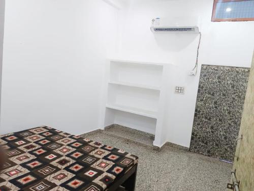 a small room with a bed and a desk at INN Shyam Bihari Guest House 500 Meter Ram mandi in Ayodhya