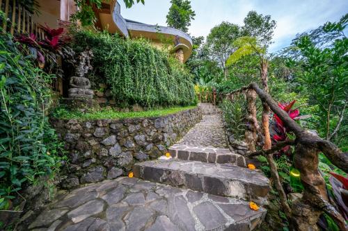 a stone path next to a stone wall at Yoga Maya Villa in Gianyar