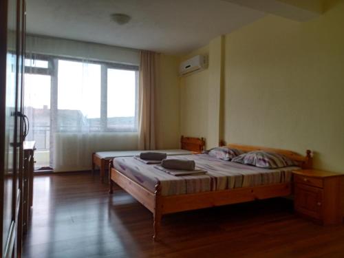 a bedroom with two beds and a large window at Guest House Diamant in Sozopol