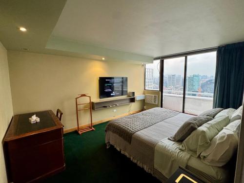 una camera d'albergo con un letto e una grande finestra di Duplex Penthouse El Golf 263 a Santiago