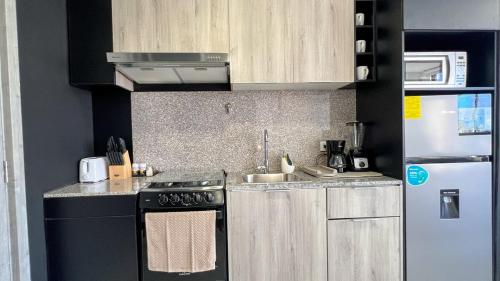 a small kitchen with a stove and a refrigerator at Apartment with city views in Financial District in Panama City