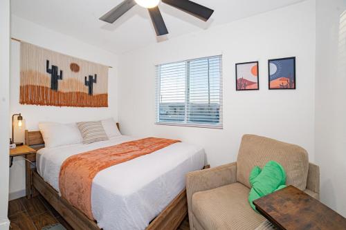 a bedroom with a bed and a chair at Cactus Cottage in Yuma