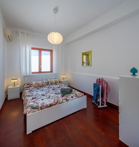 a white bedroom with a bed and a window at Villa Yasmine in Cinisi