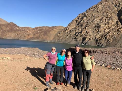 a group of people standing in front of a lake at RIAD TOUBKAL D'ATLAS TIFNOUTe in Imlil
