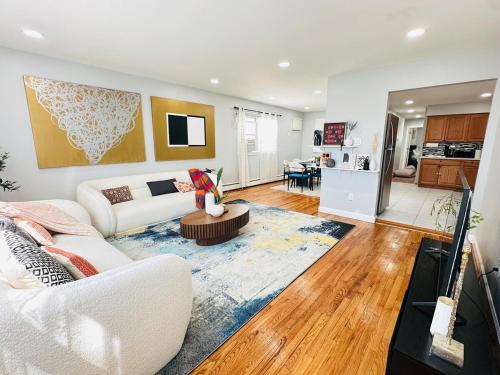 a living room with a white couch and a kitchen at The Loft at Hudson with Parking in Jersey City