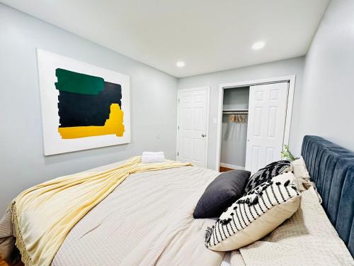 a bedroom with a bed and a painting on the wall at The Loft at Hudson with Parking in Jersey City