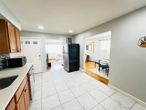a kitchen with a refrigerator and a living room at The Loft at Hudson with Parking in Jersey City