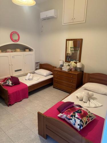 a bedroom with two beds and a dresser and a mirror at Kalymnos Beach House in Kalymnos