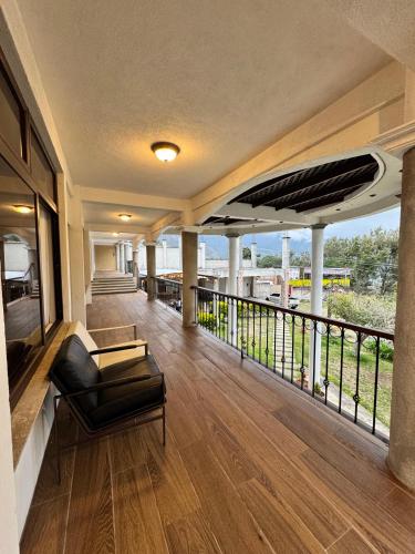 a room with a balcony with a couch and a view at Hotel Mercy in San Juan La Laguna