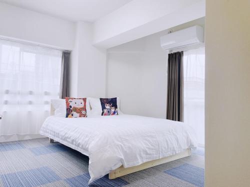 a white bedroom with a large white bed with pillows at ksi南常盤台402 in Tokyo