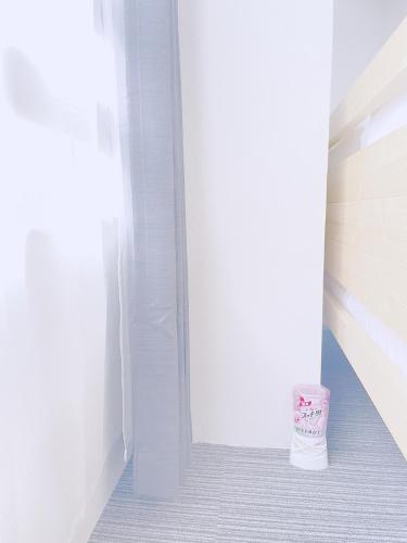 a room with a white wall and a cup on the floor at ksi南常盤台402 in Tokyo