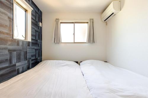 two beds in a small room with a window at jtr西船橋5丁目 in Funabashi