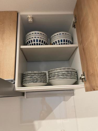 a cupboard filled with plates and bowls in a kitchen at jtr西船橋5丁目 in Funabashi