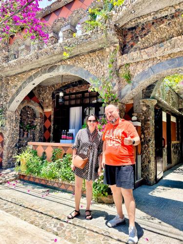 two people standing in front of a building at Sầm Sơn Boutique Hotel Phan Thiết in Phan Thiet