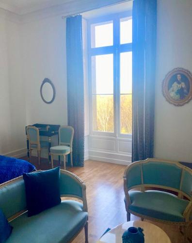 un salon avec un canapé, une table et une fenêtre dans l'établissement Château de Puycharnaud, à Lacaud