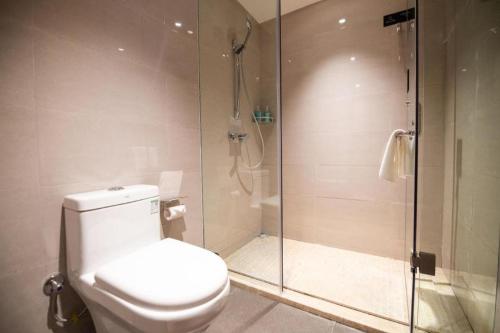 a bathroom with a toilet and a glass shower at City Comfort Inn Changsha Sifangping University of National Defense Science and Technology in Changsha