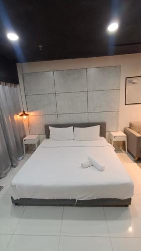 a large white bed in a room with two tables at Summer Suites KLCC by CozyNest in Kuala Lumpur