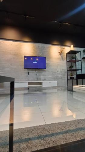 a room with a tv on a wall at Summer Suites KLCC by CozyNest in Kuala Lumpur