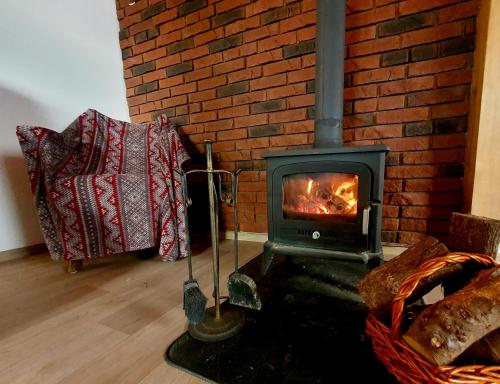 a stove in a living room with a brick wall at Antera Peaceful Escape in Gorowychy Małe