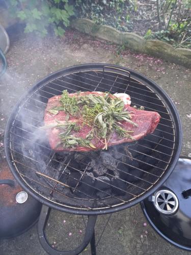 un morceau de viande cuisine sur un grill dans l'établissement Yourte calvados, à Les Moutiers-en-Auge