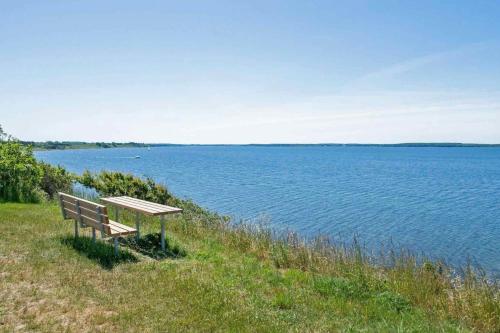 a bench sitting on the side of a body of water at The Wonderful Hornsherred And Isefjord in Skibby